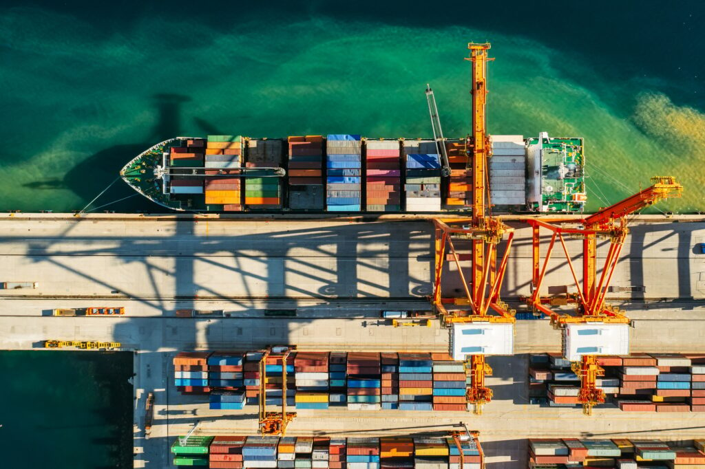 Aerial view of containers loading and unloading to the ship in the sea port. Logistic and